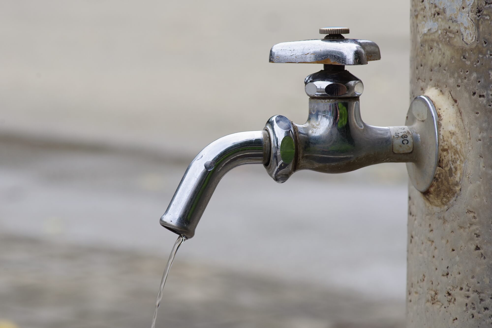 ちょろちょろと蛇口から水漏れしている屋外水栓のアップ